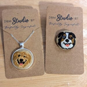 An embroidered dog pin of a golden retriever and an Australian shepherd
