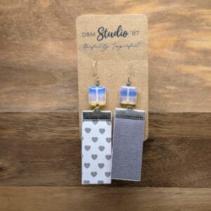 Rectangle scrapbook paper medium size earrings with felt core and mod podged finish. Front is white with gray hearts, back is a textured gray. Featuring irridecsent beads and silver finishes. Back Shown