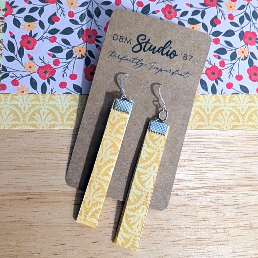 Slim, lightweight mismatched dangle earrings featuring a warm mustard-yellow design on the back finished with silver-tone hooks.
