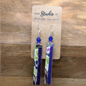 Earrings with green, pink, purple florals and blue-purple swirls with a blue bead and silver findings.